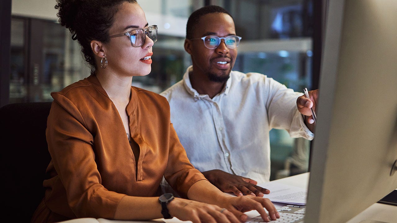 Des employés planifiant une stratégie marketing dans un bureau sombre.