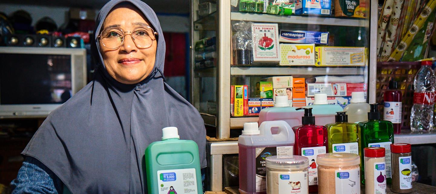 Nur Syamsiah holds an Alner bottle in her store. 