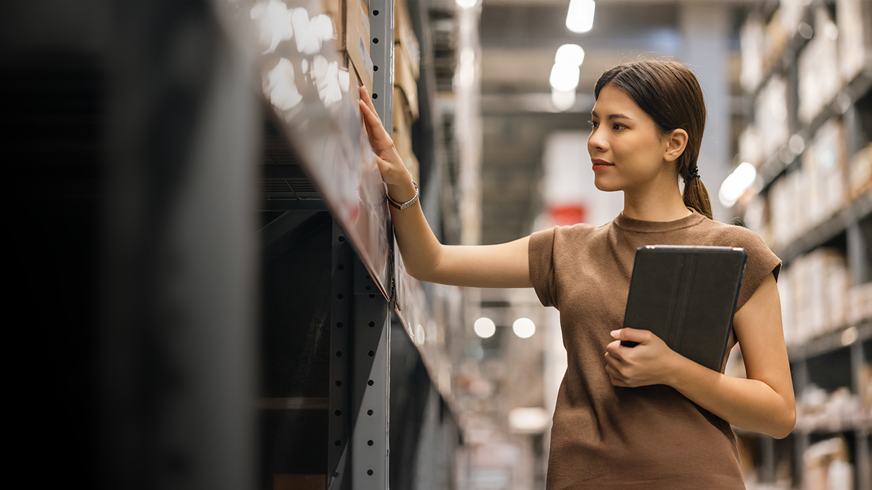 Mujer revisando el inventario en un almacén.