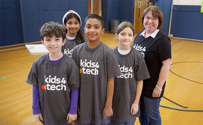Los niños y su maestra con camisetas de Kids4Tech.