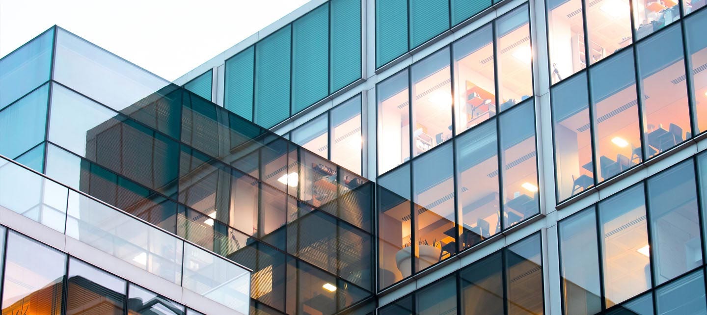 Un bâtiment moderne avec de multiples fenêtres et une grande façade vitrée. 