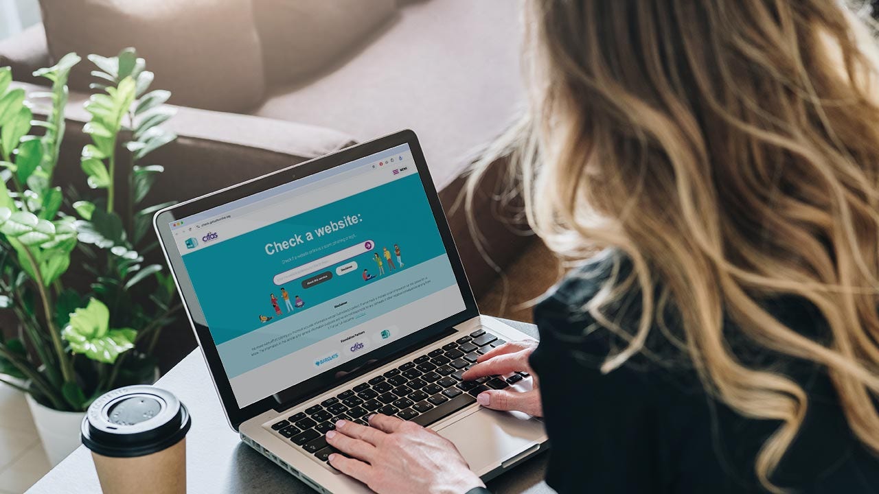Mujer usando una herramienta de verificación de sitios web en su computadora portátil.