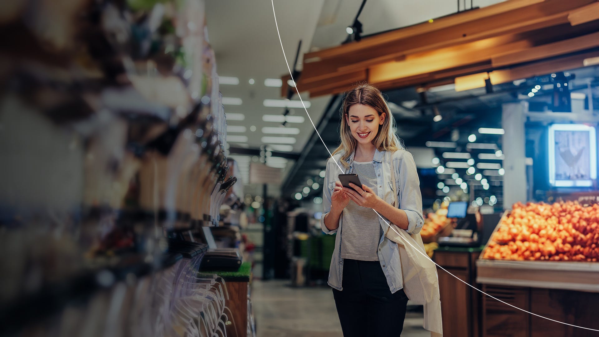 Woman looking at phone in supermarket