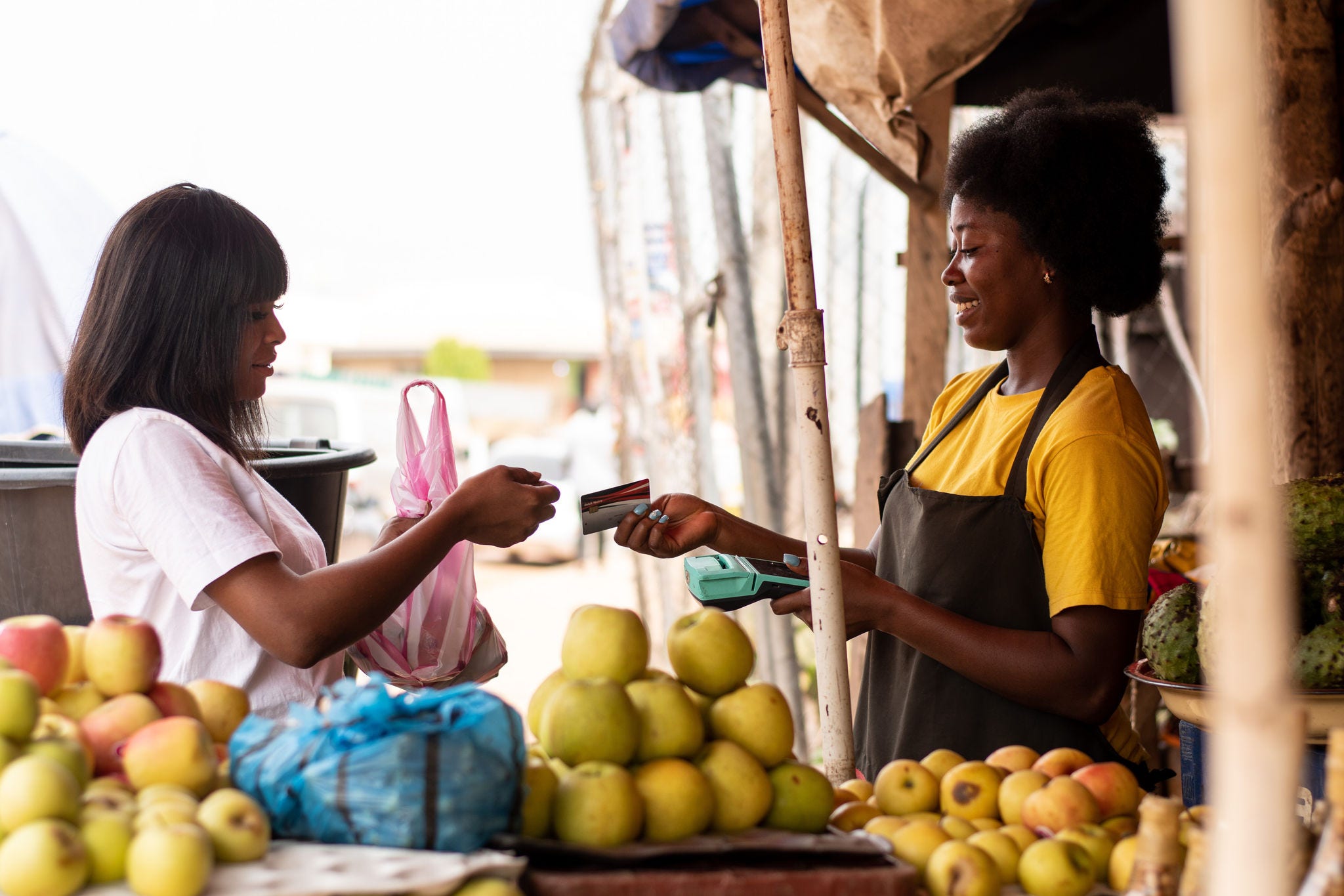 Una mujer pagando fruta a un vendedor