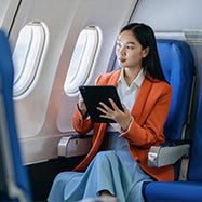 young business woman working on a tablet while sitting in an aeroplane.