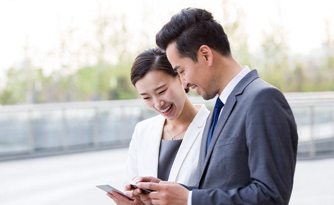 Asian couple looking at their phones