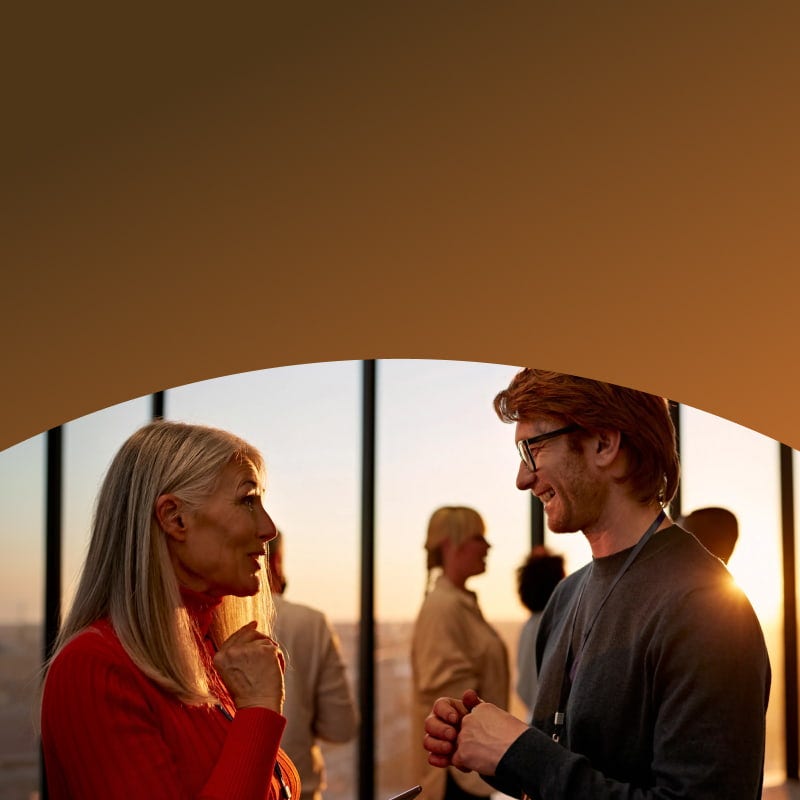 man and woman talking at a conference