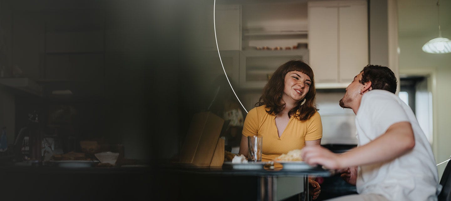 Un homme et une femme sont assis à une table et se regardent.
