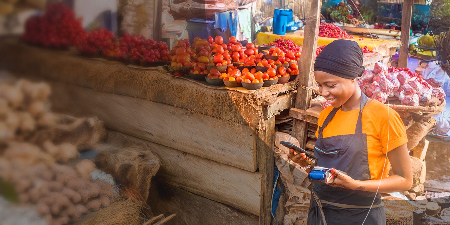 Woman processing digital payment at market stall