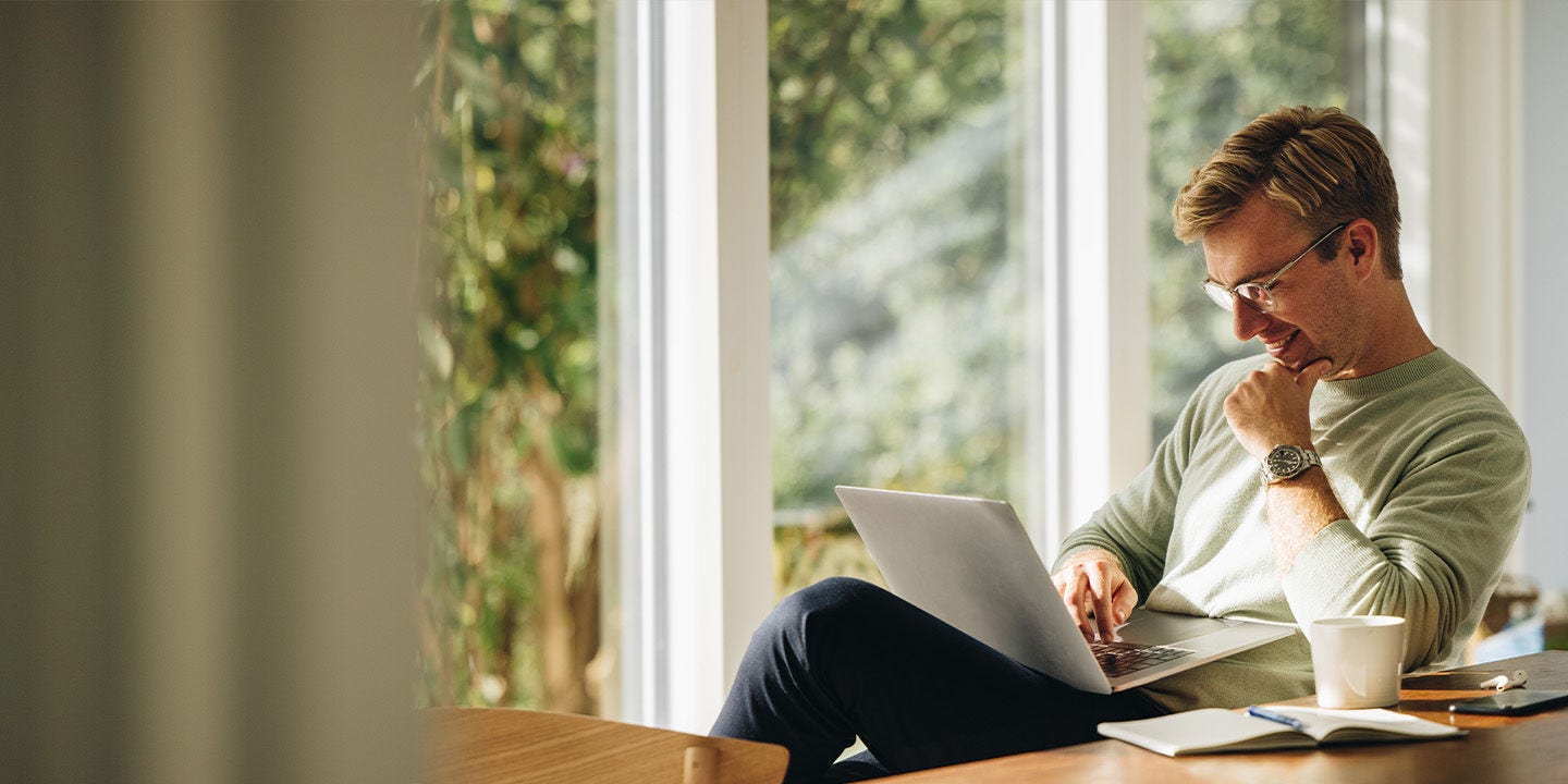 Man wearing a green sweatshirt working from home