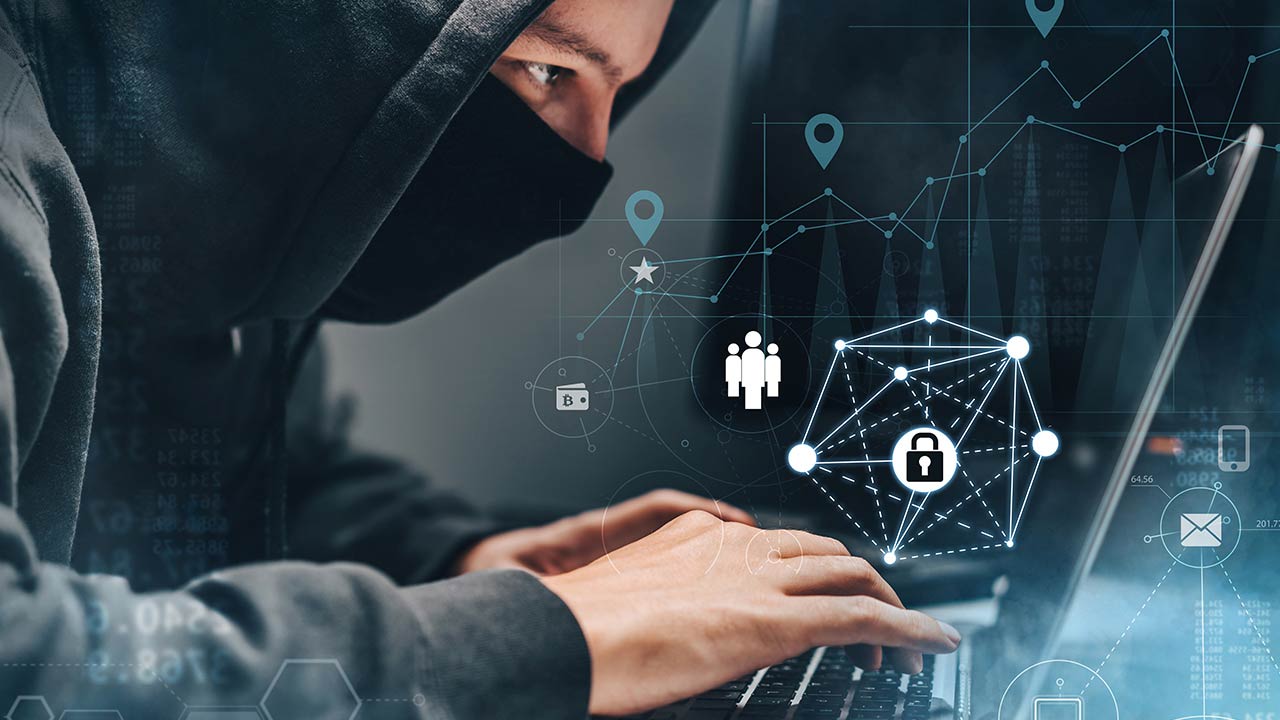 Hombre con sudadera trabajando en una computadora portátil.