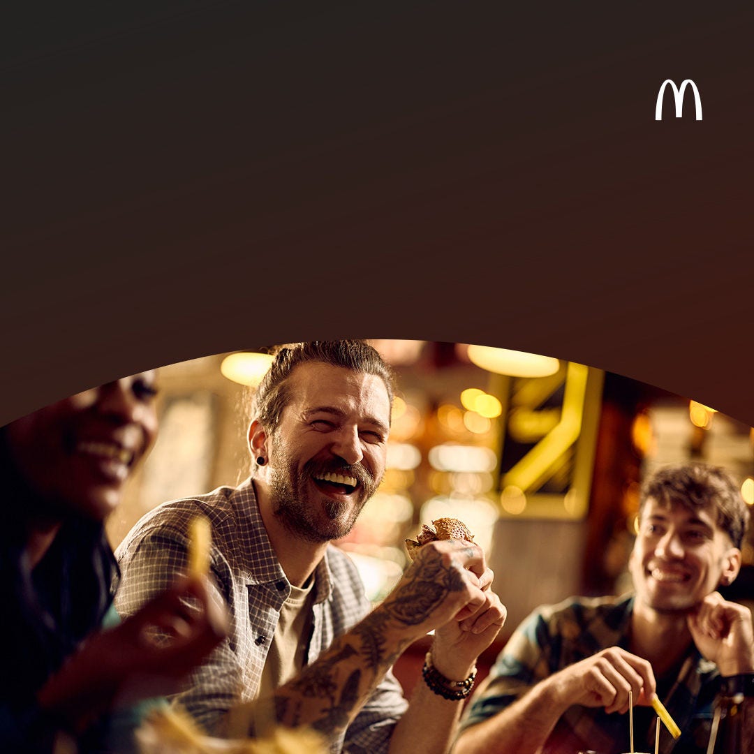 Amigos riendo y disfrutando de una comida en un restaurante de comida rápida.