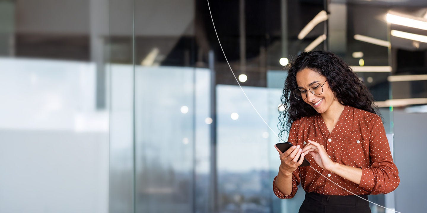 Mujer de negocios usando el teléfono en el lugar de trabajo.